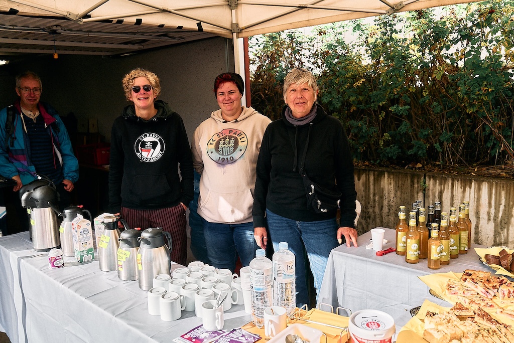 Helferinnen stehen hinter einem reichhaltig ausgestatteten Catering-Tisch zusammen