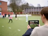 Ein junger Mann filmt das Trainingsgeschehen mit einem Tablet
