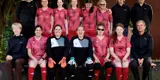 Teamfoto der Spielerinnen in roten Trikots und staff