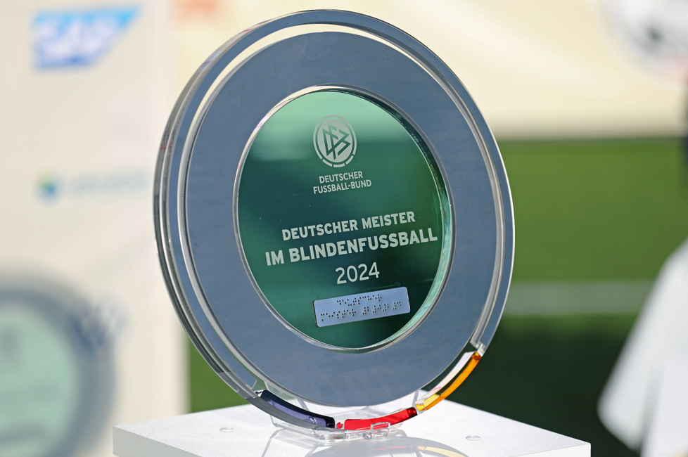 Großaufnahme der Meisterschale 2024 aus Glas auf einem Sockel