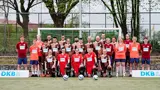 Das Liga-Team steht und kniet vor einem Tor mit DKB-Banden an dem Seiten. vlnr: Wolf Schmidt, Rasmus Heidmann, Julius Kolbeck, Moijtaba Safari, Philipp Versen, Jenny Dabelstein, Natan Werner, Paul Ruge, Pelle Gronau, Thoya Küster, Serdal Çelebi, Svenja Bartels, Calvin Runge, Michael Löffler, Sven Gronau, Victor Pfaul, Rasmus Narjes, Jana Marquart, Antje Küster, Thore Winter, Helene Bischoff, Michael Hain, Gunther Damm, Jonas Dawid 